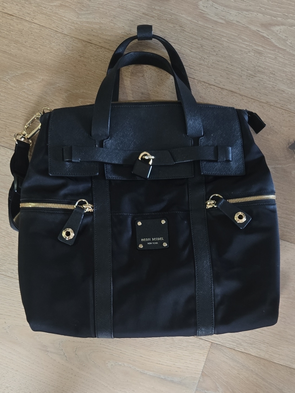 henri bendel black exterior with purple interior and cream trim handbag/backpack